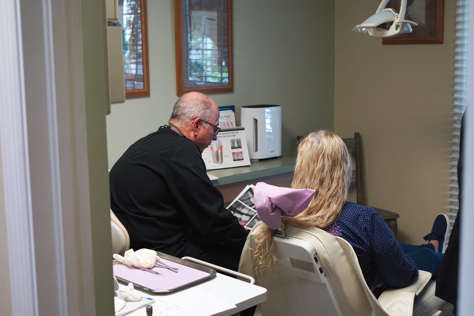 Dr. Bergens reviewing X-rays and implant options with a patient