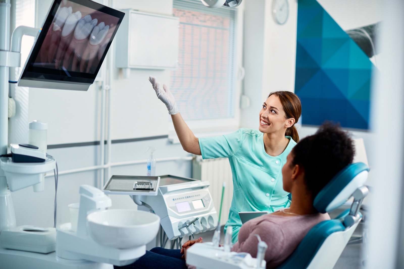 A hygienist walking a patient through her dental X-rays